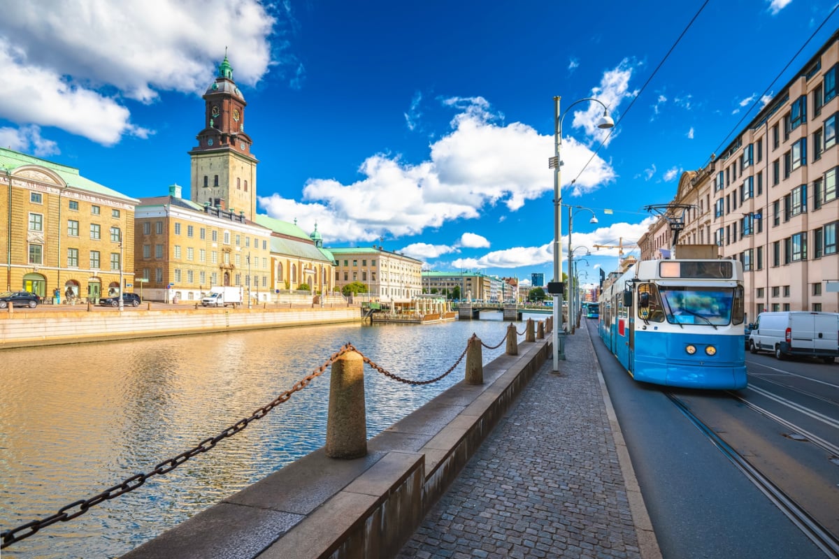 Clock tower and tram passing Gothenburg canal